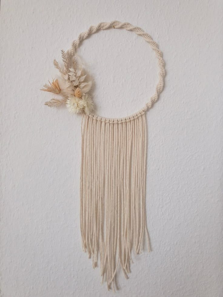 Saaika Crafts macrame wall hanging on a metal ring decorated with dried flowers and cream cotton cord