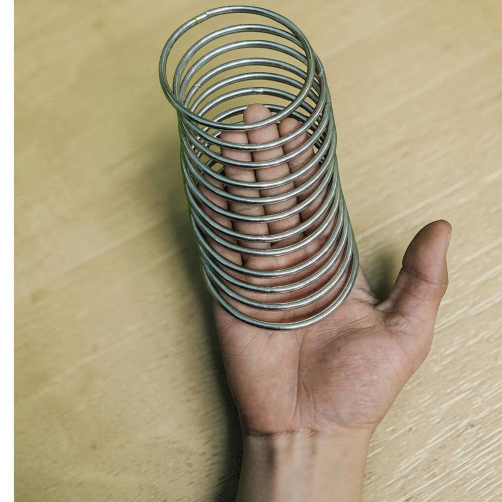 Saaika Crafts stack of silver steel metal rings for macrame, dream catchers, and DIY craft projects held in a hand.